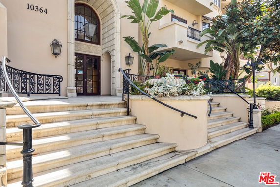 Front view of a building with arched entrance and multiple staircases.