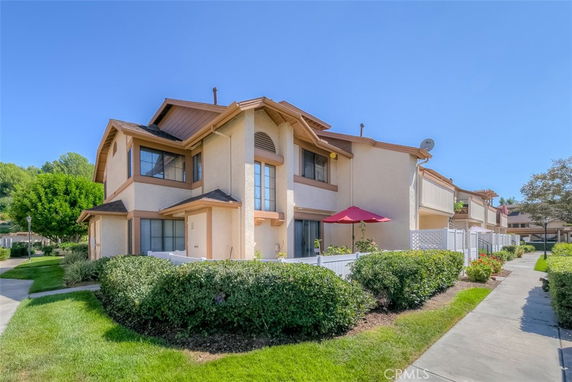 Front view of a two-story residential building with a fenced patio.
