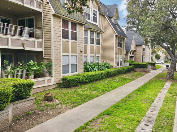 Front view of a multi-story residential building with balconies and large windows.