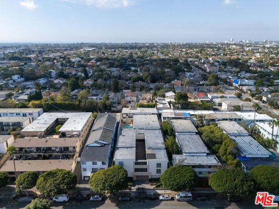 Aerial view of urban area with multiple residential buildings and surrounding landscape.