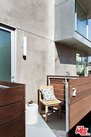 Outdoor view of a modern house with a small balcony and wooden railing.