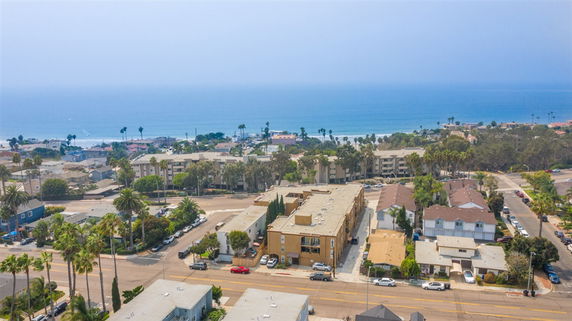Aerial view of a coastal neighborhood with ocean in the background.