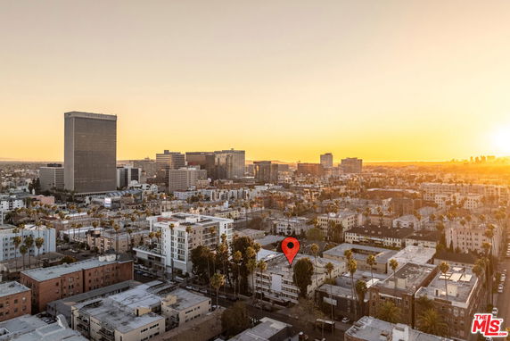 Wide angle view of a city skyline at sunset with multiple buildings.
