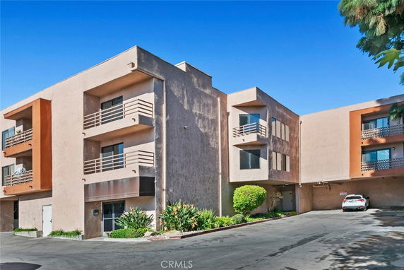 Front view of a multi-story apartment building with balconies.