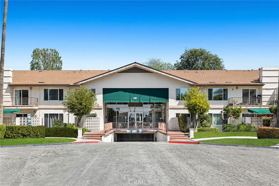 Front view of a two-story building with a central entrance and green awnings.
