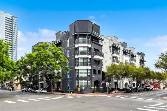 Front view of a multi-story residential building on a street corner.