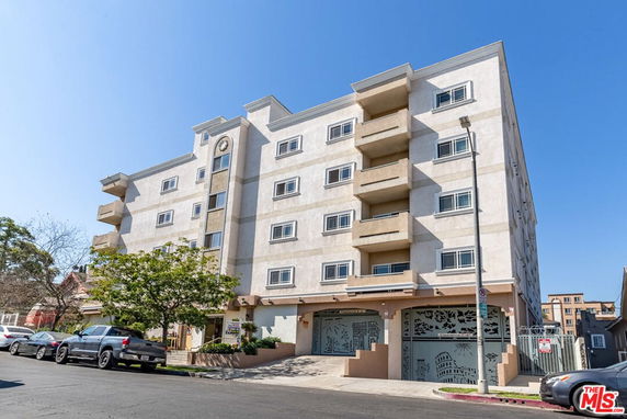 Front view of a multi-story apartment building with balconies.
