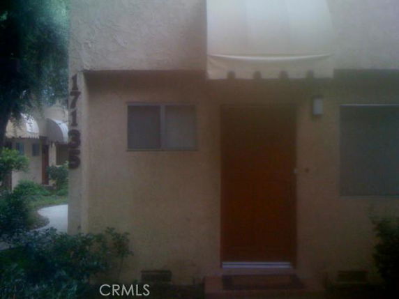 Front view of a house with a single door and small windows.