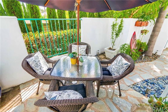 Outdoor patio area with wicker furniture and an umbrella.