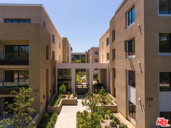 View of a multi-story apartment building with beige exterior and balconies.