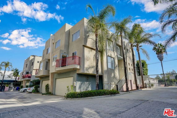 Front view of a multi-story residential building with a garage.
