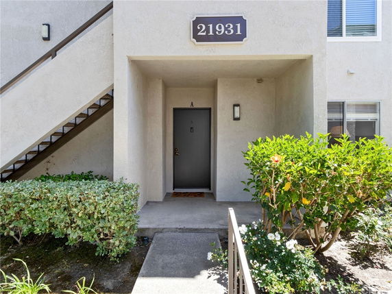Front view of a building entrance with a door marked 'A', stairs to the left, and a nameplate with the number '21931'.