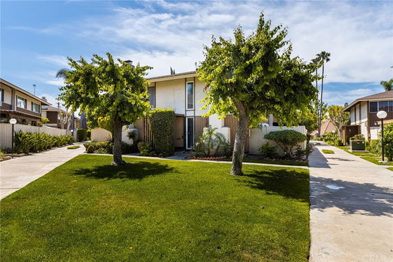 Front view of a two-story house with trees and a pathway.