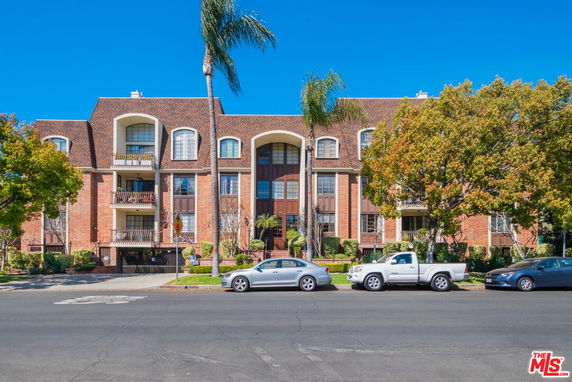 Front view of a multi-story residential building with covered balconies.