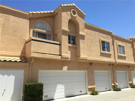 Front view of a row of townhouses with garages.