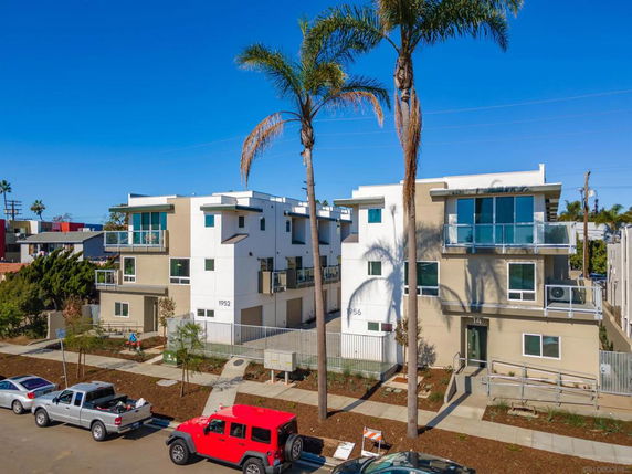 Front view of a multi-story modern apartment building with balconies.