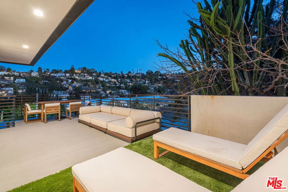 Outdoor terrace with seating area and view of surrounding neighborhood.