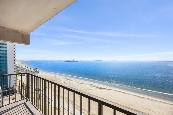 Wide angle view of a beach and ocean from a building balcony.