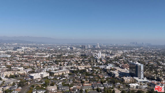 Wide-angle view of a cityscape with numerous buildings and city structures under a clear sky.