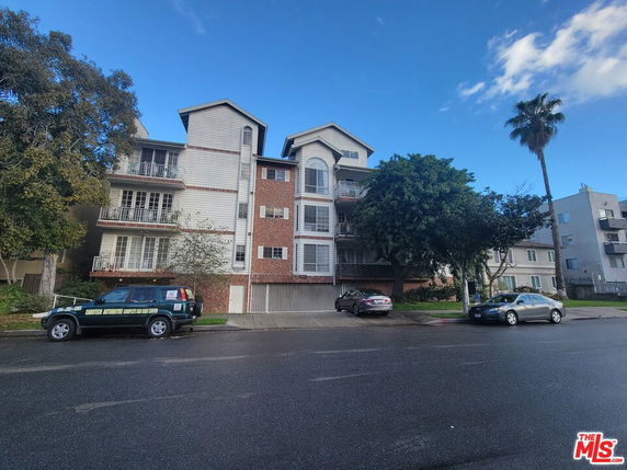 Front view of a multi-story residential building with balconies.