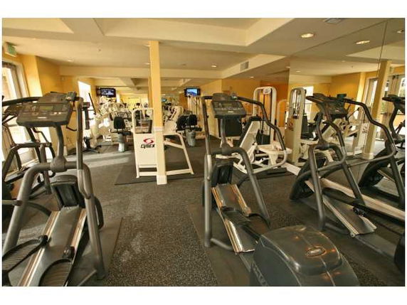 Indoor gym area with various exercise equipment including treadmills and ellipticals.