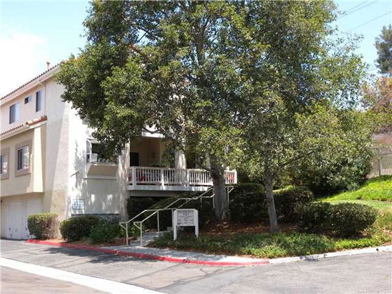 Front view of a two-story building with an external staircase and porch.