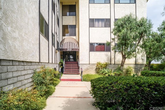 Front view of a multi-story building with an entrance canopy and steps.