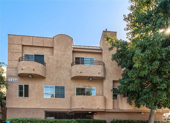 Front view of a multi-story building with balconies and a central entrance.