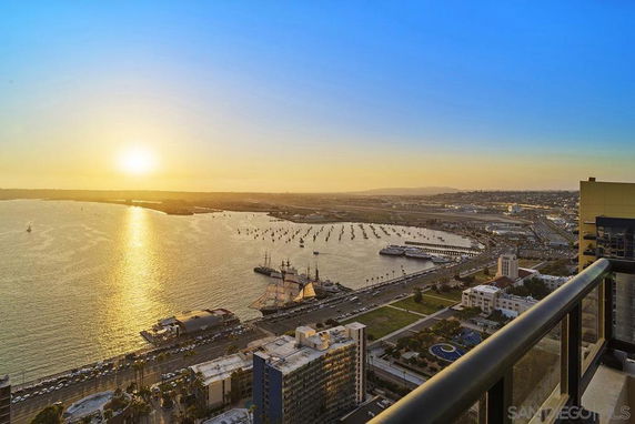 Panoramic view overlooking a bay with a sunset, seen from a high-rise building.