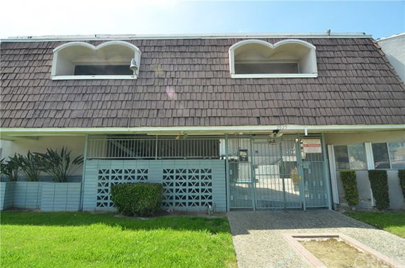 Front view of a two-story building with arched windows and a tiled roof.