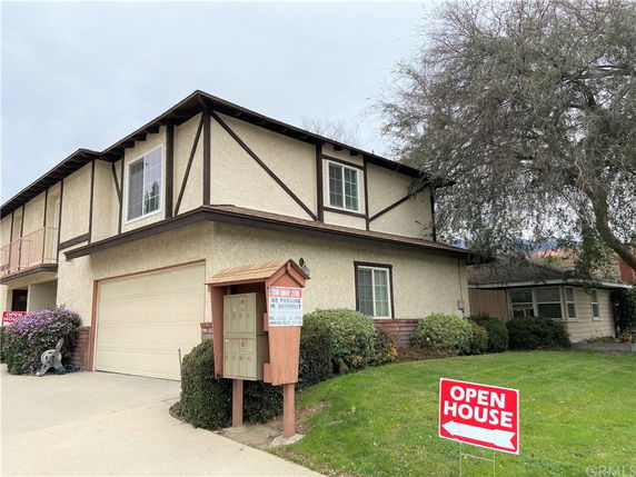 Front view of a two-story house with a garage and open house sign.
