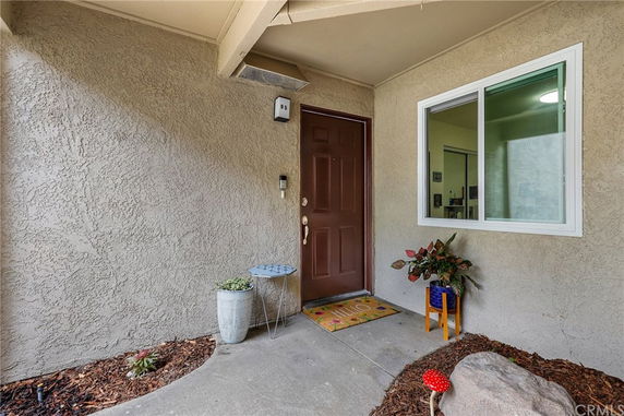 Front entrance of a house with a brown door and a window beside it.