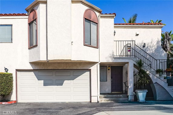 Front view of a two-story house with a garage and stairway.