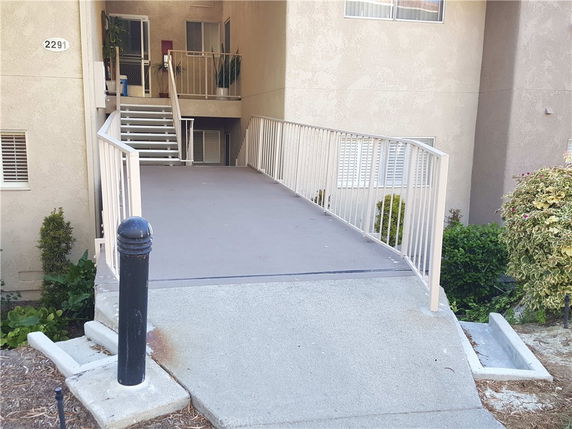 Front view of a building entrance with a ramp and stairs.