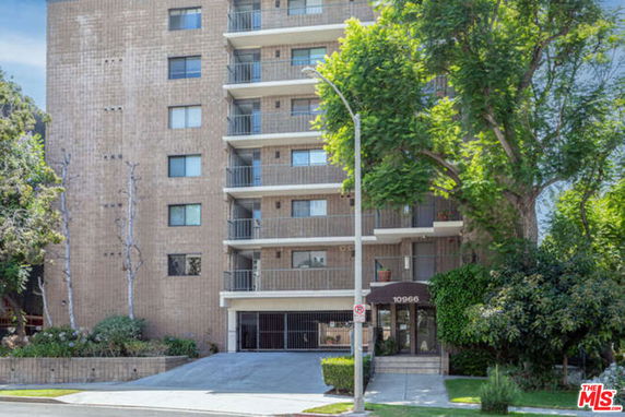 Front view of a multi-story apartment building with balconies.
