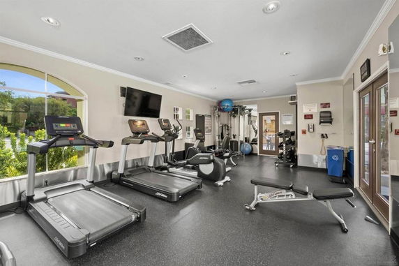 Indoor gym area with fitness equipment and large windows.