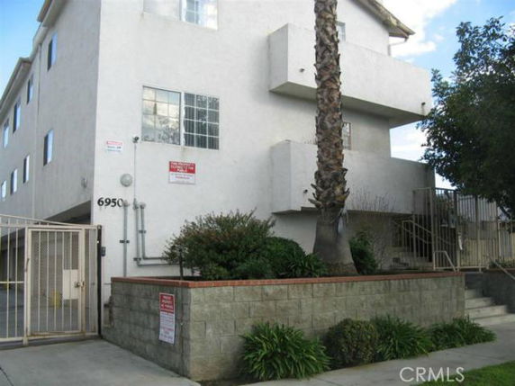 Front view of a multi-story building with a gated entrance.