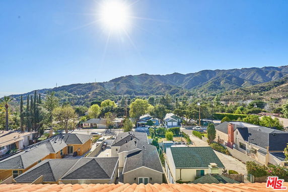 Panoramic view of residential area with mountains in the background.