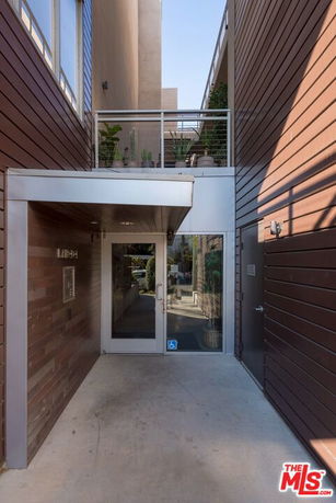 Entrance of a modern building with glass door and wooden paneling.