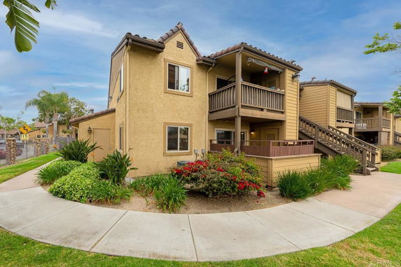 Front view of a two-story apartment building with outdoor stairs and balconies.