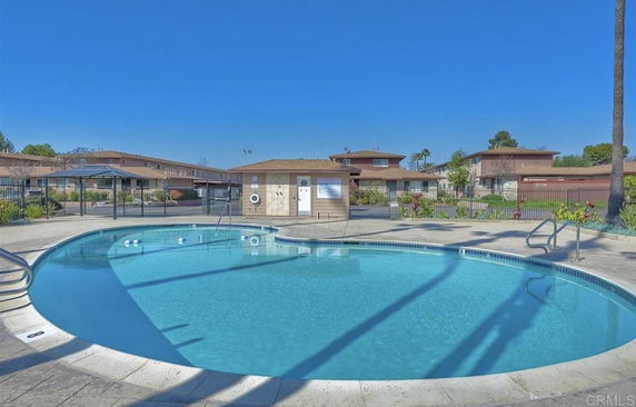 Outdoor swimming pool area with surrounding buildings.