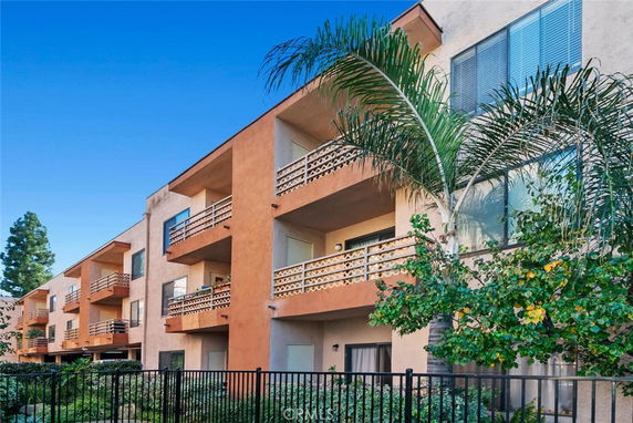 Front view of a multi-story apartment building with balconies.