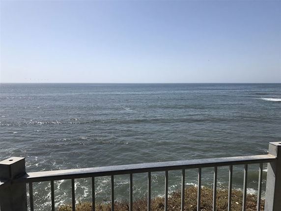 Panoramic view of the ocean from a railing perspective.