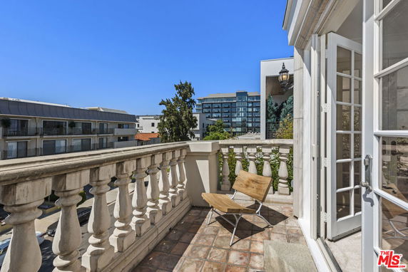 Balcony view of surrounding buildings and clear blue sky.