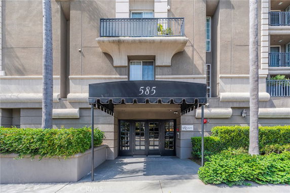 Front view of a building entrance with a black awning labeled 585.