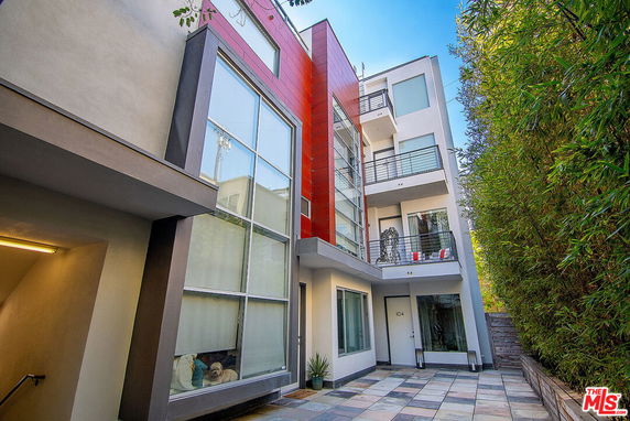 Front view of a multi-story modern building with large windows and balconies.
