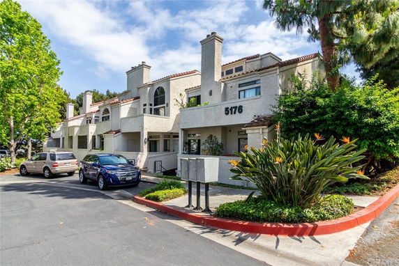 Front view of a multi-story residential building with balconies and garage area.