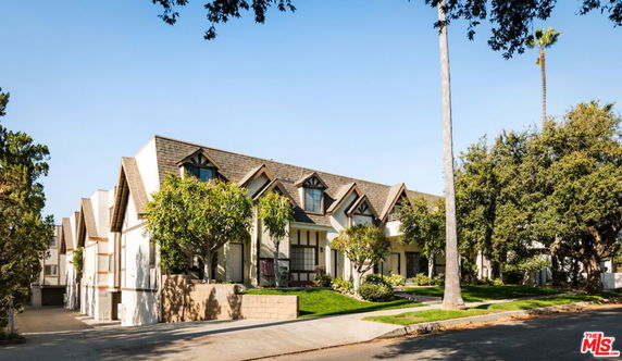Front view of a multi-story building with peaked roofs and large windows.