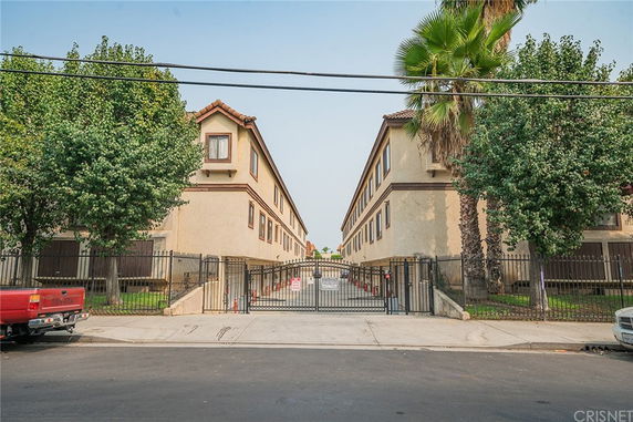 Front view of a multi-story residential building with gated entrance.