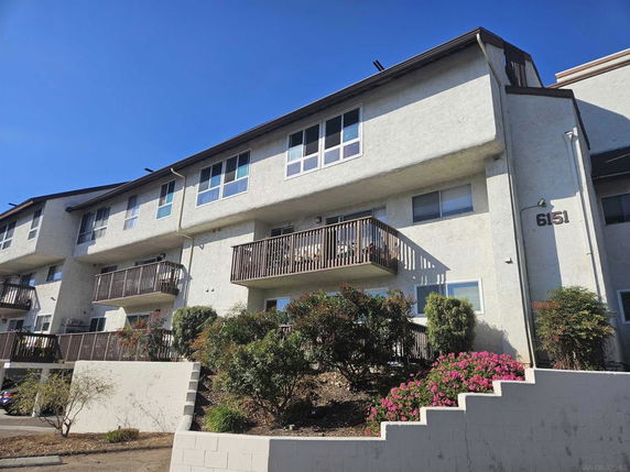 Front view of a multi-story residential building with balconies.